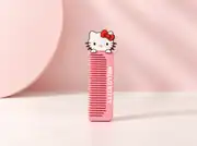 Kedi figürlü pembe tarak dik duruşta