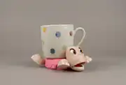 Pembe kaplumbağa bardak altlığı üzerinde puantiyeli kupa