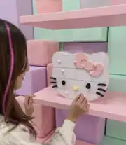 Kedi figürlü takı kutusunu açan çocuk, pastel rafta