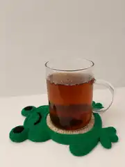 Kurbağa bardak altlığında cam bardakta çay