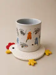 Tavuk bardak altlığı üzerinde desenli kupa
