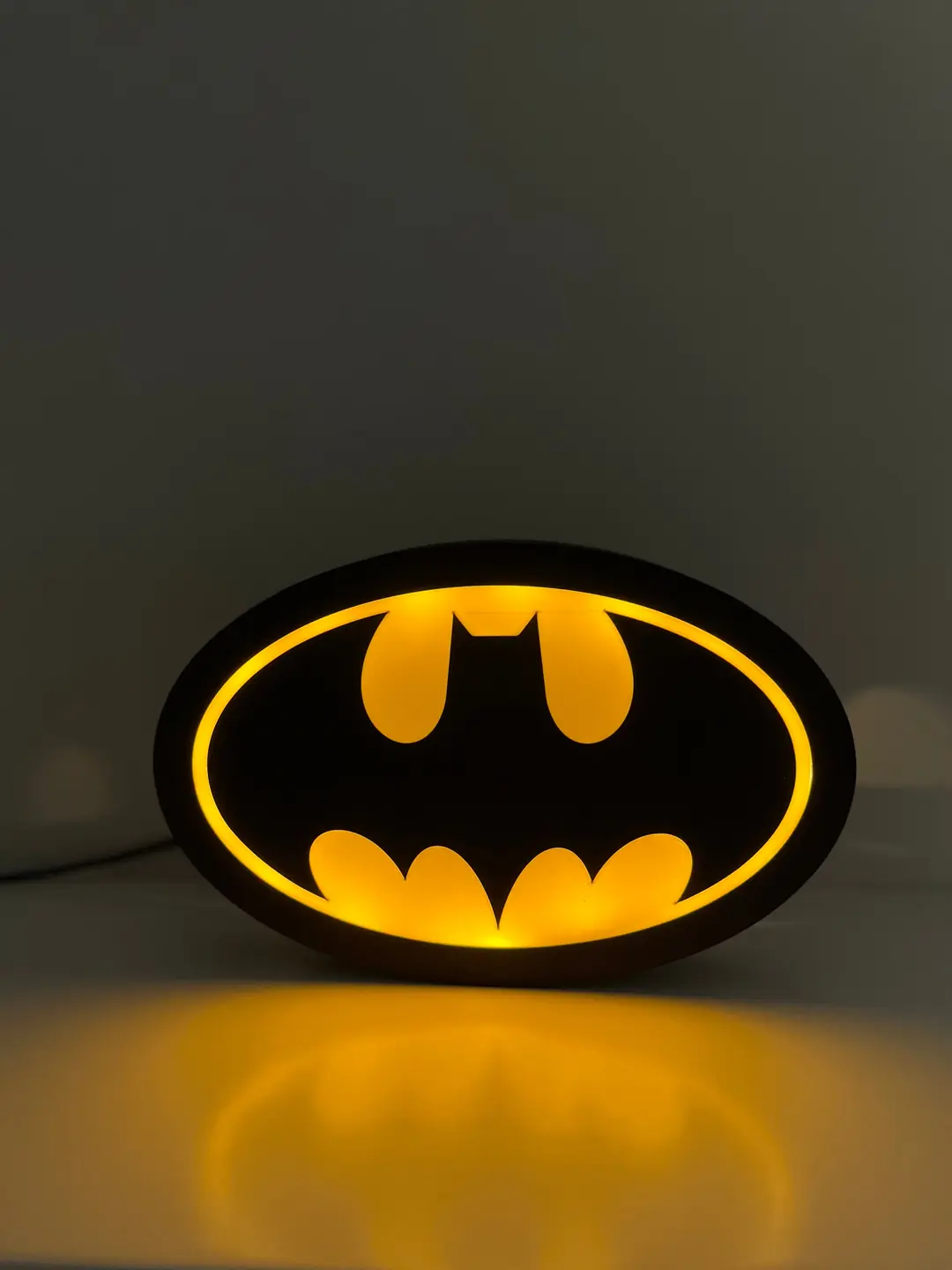 Batman logolu LED gece lambası yanarken, masa üstünde