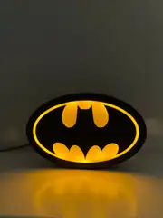 Batman logolu LED gece lambası yanarken, masa üstünde